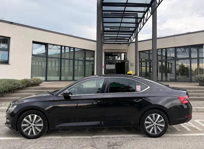 Чорна Škoda Superb Taxi Cieszyn біля готелю